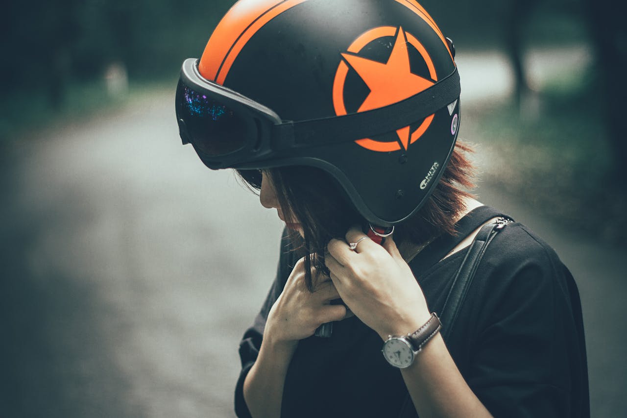 A woman adjusting a safety helmet on an outdoor road, emphasizing protective gear.